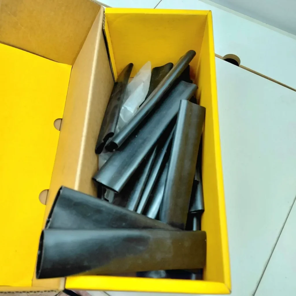 Tubos termocontraíbles negros en una caja amarilla. by Remates Narvaja