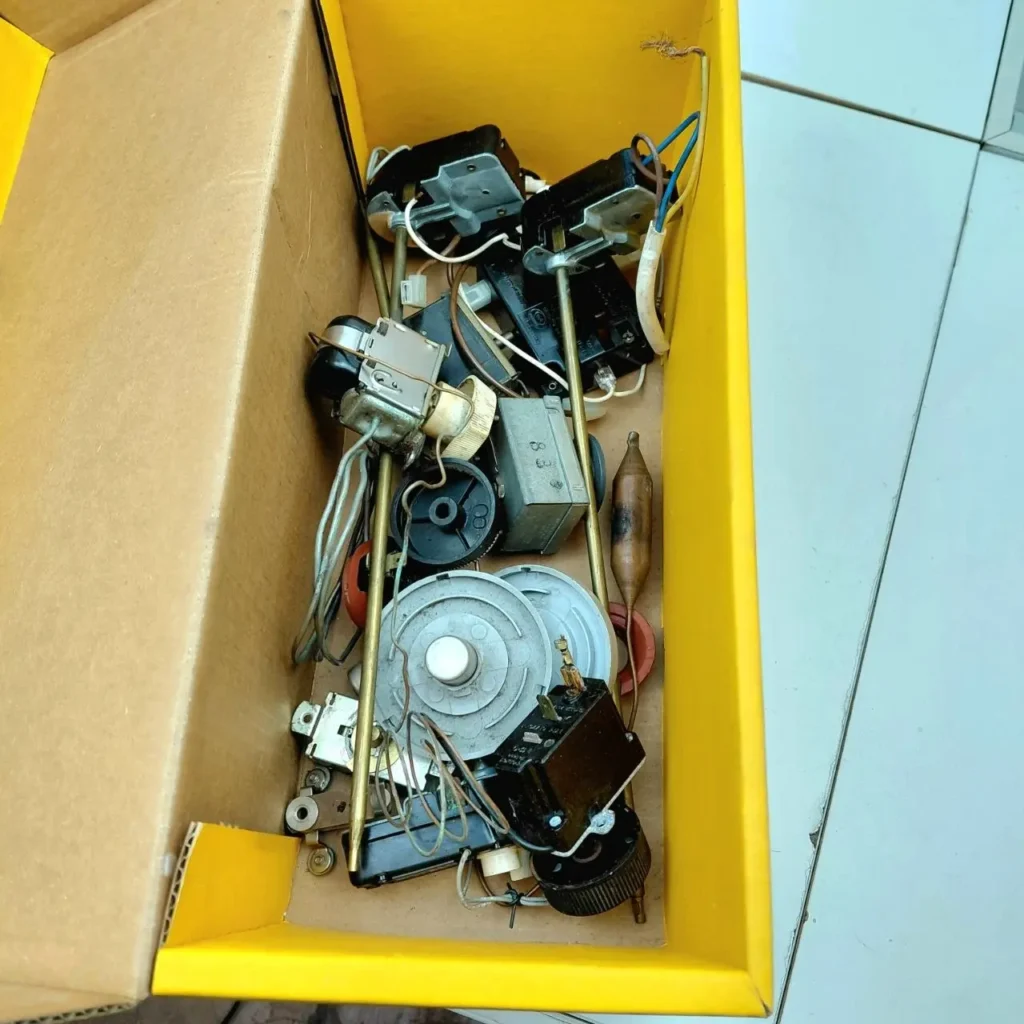 Caja con termostatos, perillas y varios componentes eléctricos para electrodomésticos. by Remates Narvaja