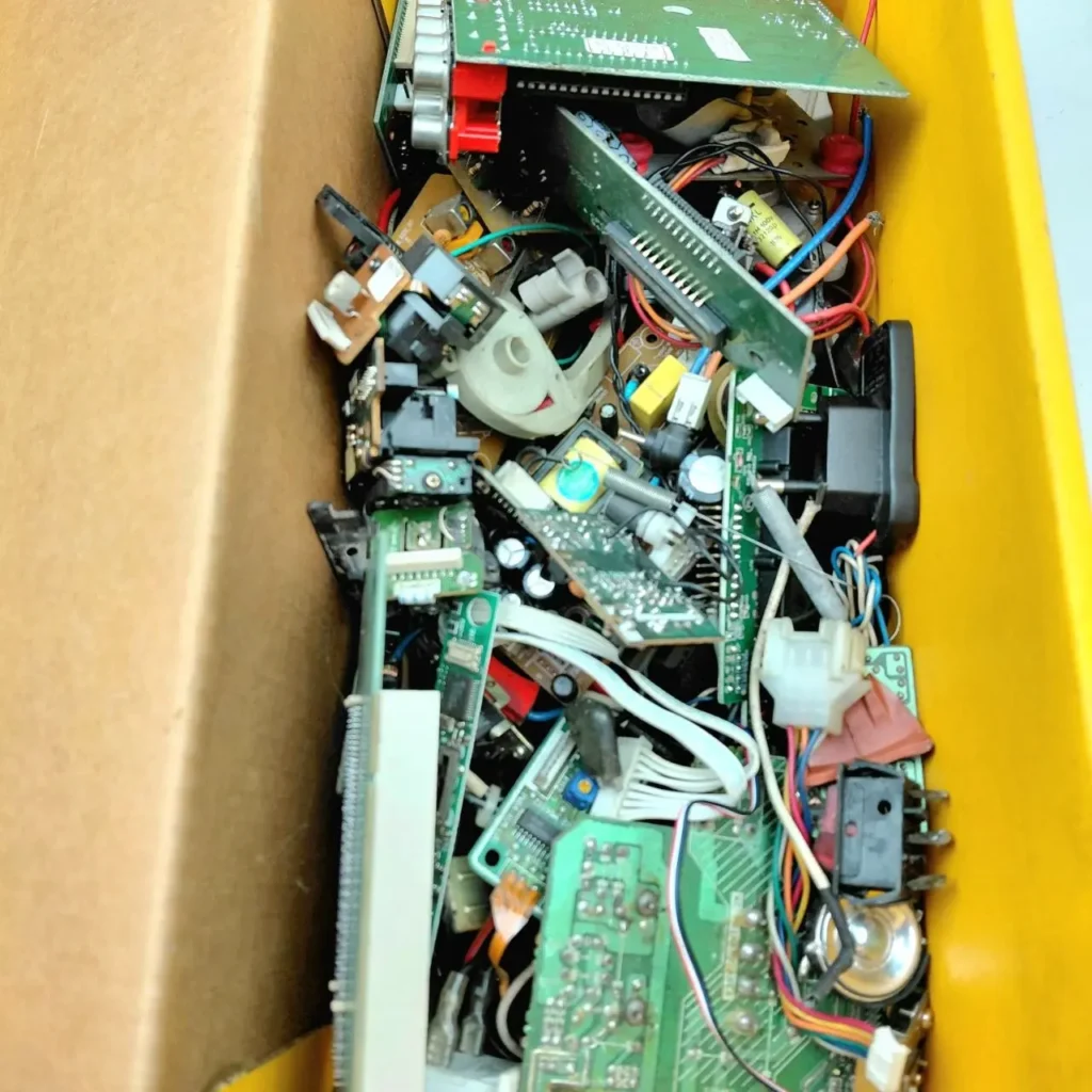 Caja llena de placas de circuito, cables y componentes electrónicos variados. by Remates Narvaja