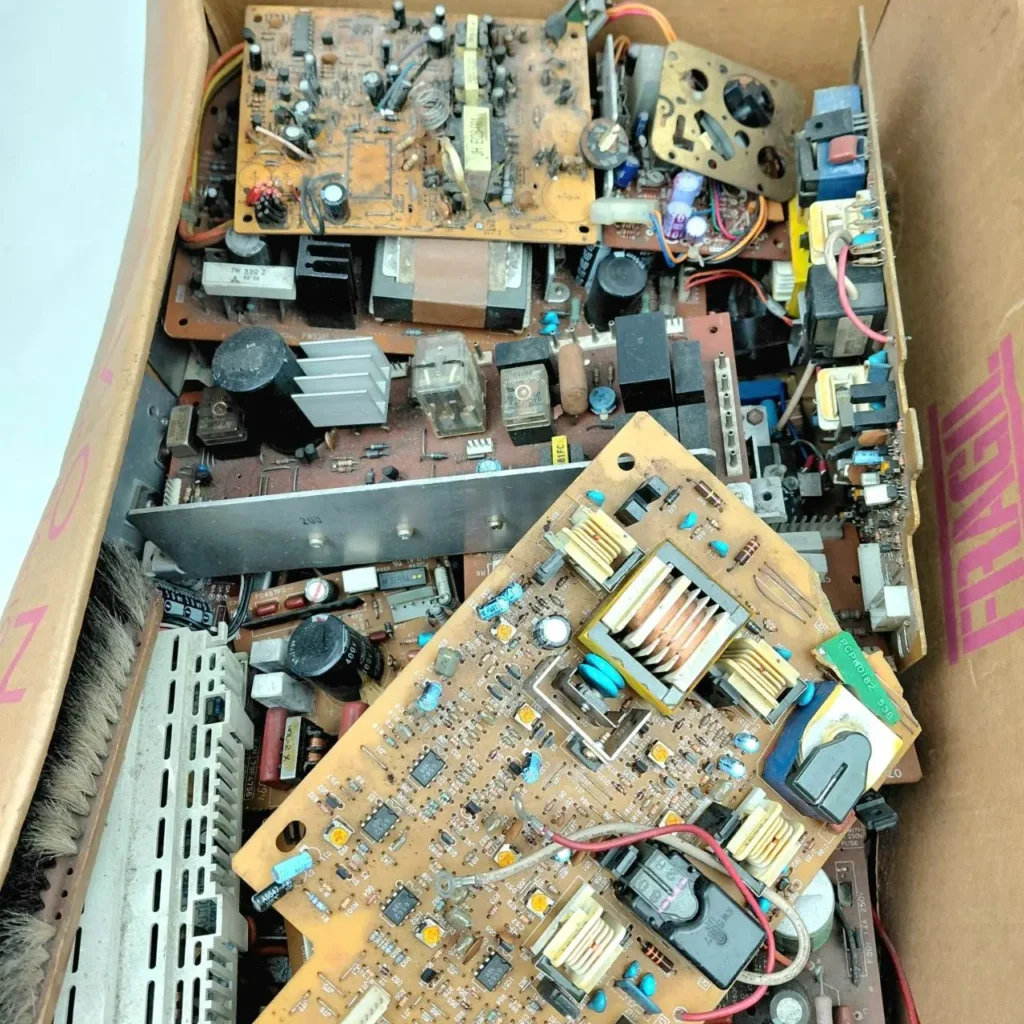 Caja de cartón llena de placas de circuito electrónico y componentes de desecho. by Remates Narvaja