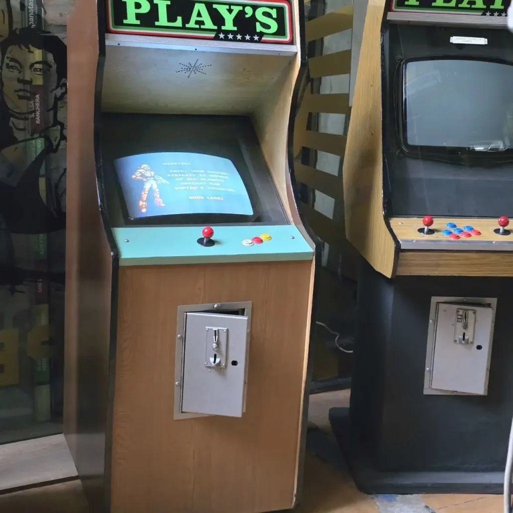 Máquinas arcade retro de madera y negras, una con un juego de disparos en pantalla y monedero abierto. by Remates Narvaja