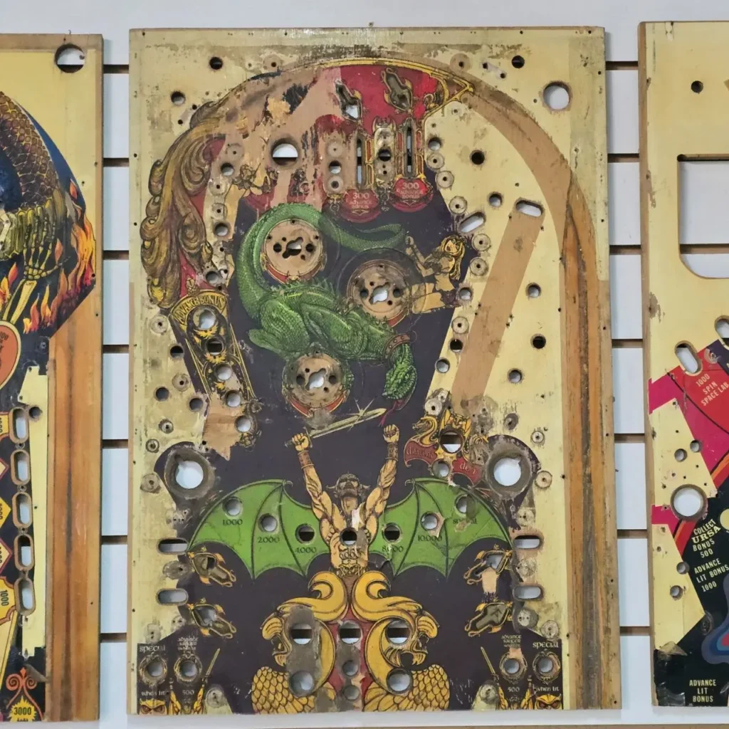 Tableros de pinball vintage desgastados con arte de fantasía: un dragón verde y un guerrero alado. by Remates Narvaja