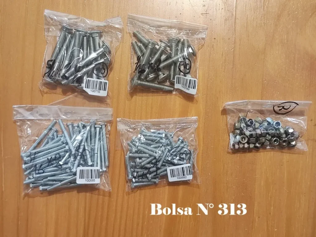 Surtido de tornillos, pernos y tuercas en bolsas transparentes sobre madera. by Remates Narvaja