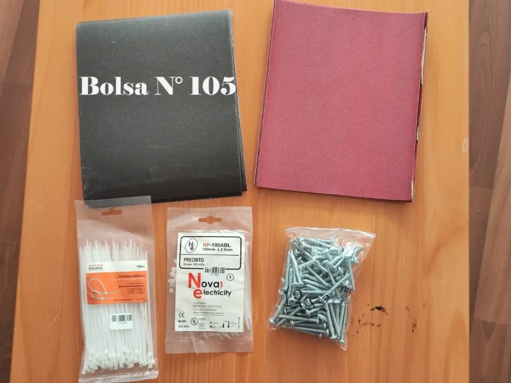 Carpeta "Bolsa N° 105", precintos plásticos y tornillos en una mesa de madera.** by Remates Narvaja