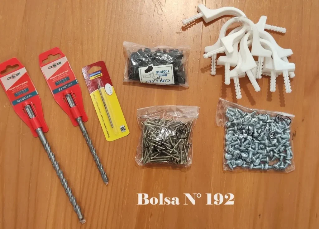 Surtido de brocas, tornillos y clips para cables en empaques sobre madera. by Remates Narvaja