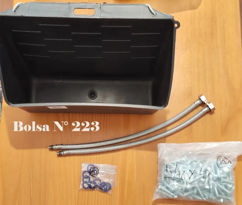 Contenedor de plástico negro con desagüe, dos mangueras flexibles, tornillos y arandelas, etiquetado como "Bolsa by Remates Narvaja