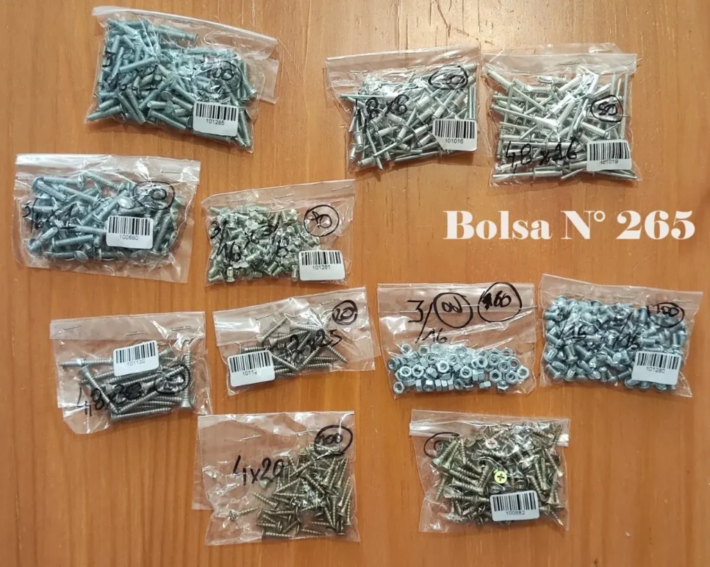 Variedad de tornillos, tuercas y remaches en bolsas plásticas sobre una superficie de madera, con la etiqueta "Bolsa N° by Remates Narvaja
