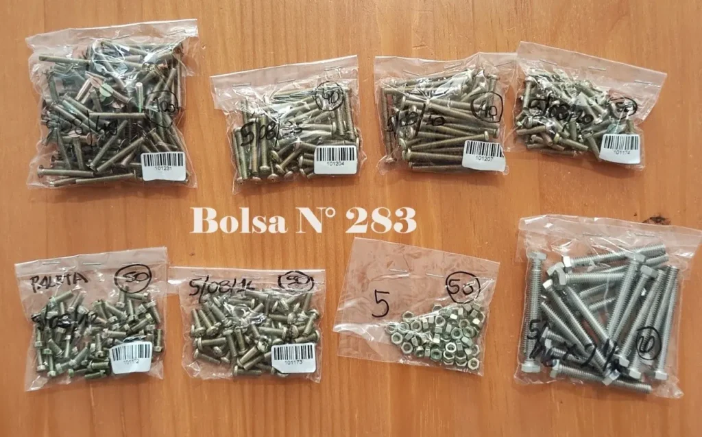Surtido de tornillos, tuercas y pernos en varias bolsas transparentes, con la etiqueta "Bolsa N° 28 by Remates Narvaja