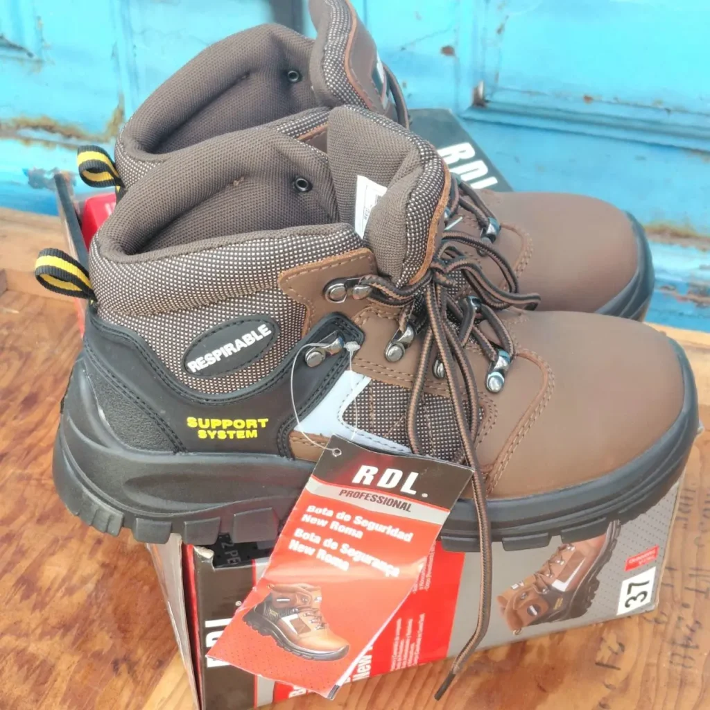 Un par de botas de seguridad RDL Professional New Roma de color marrón, con etiquetas que indican "Respirable" y "Support System", sobre su by Remates Narvaja