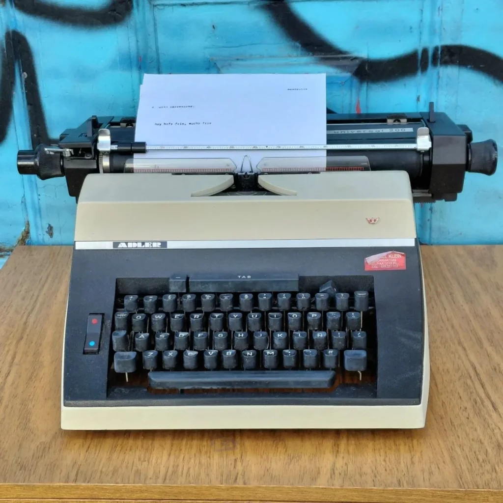 Máquina de escribir vintage Adler Universal 200 con texto en papel. by Remates Narvaja