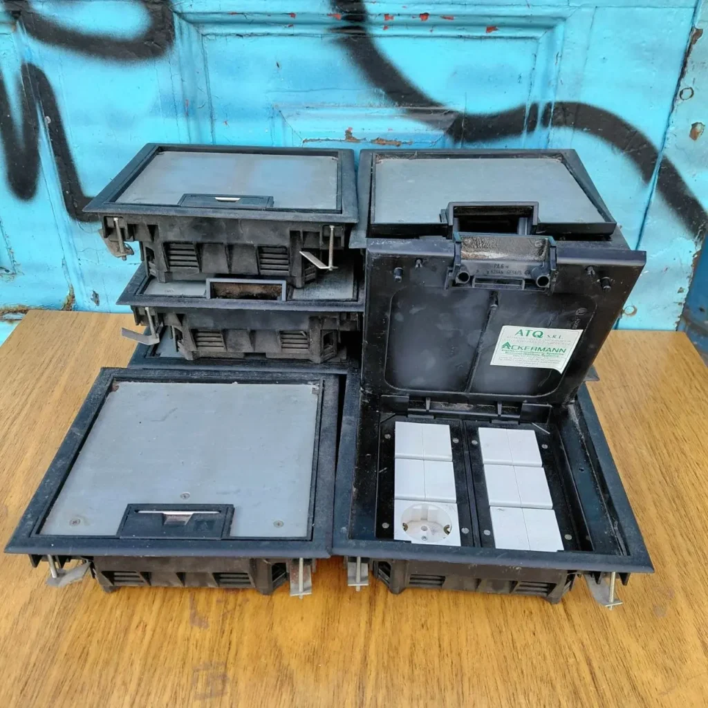 Cajas de suelo eléctricas Ackermann, una abierta con toma de corriente y módulos. by Remates Narvaja