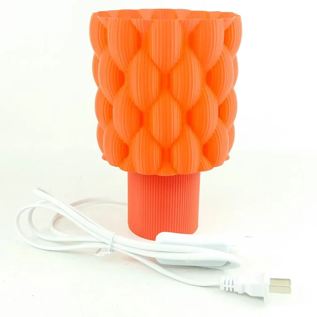 Lámpara de mesa naranja brillante con diseño texturizado y cable blanco. by Remates Narvaja