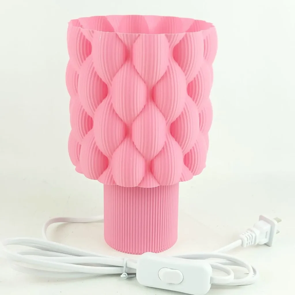 Lámpara de mesa rosa con pantalla texturizada de burbujas o escamas y base acanalada. by Remates Narvaja