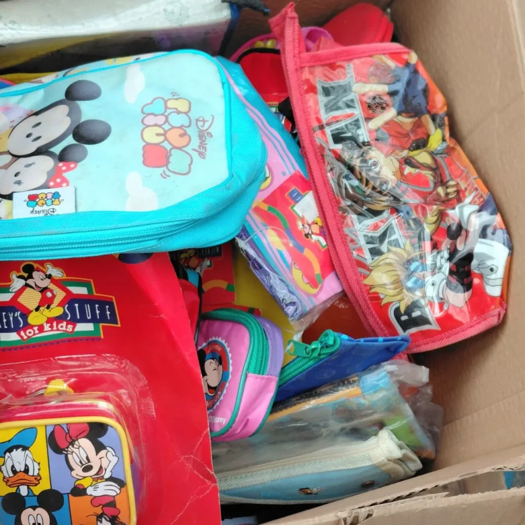 Caja llena de bolsas, estuches y loncheras coloridas con personajes de Disney como Mickey Mouse, Minnie Mouse y Tsum T by Remates Narvaja