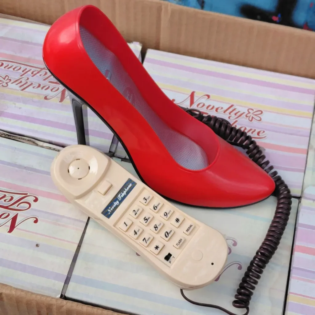 Teléfono de novedad con forma de zapato de tacón rojo y auricular beige. by Remates Narvaja