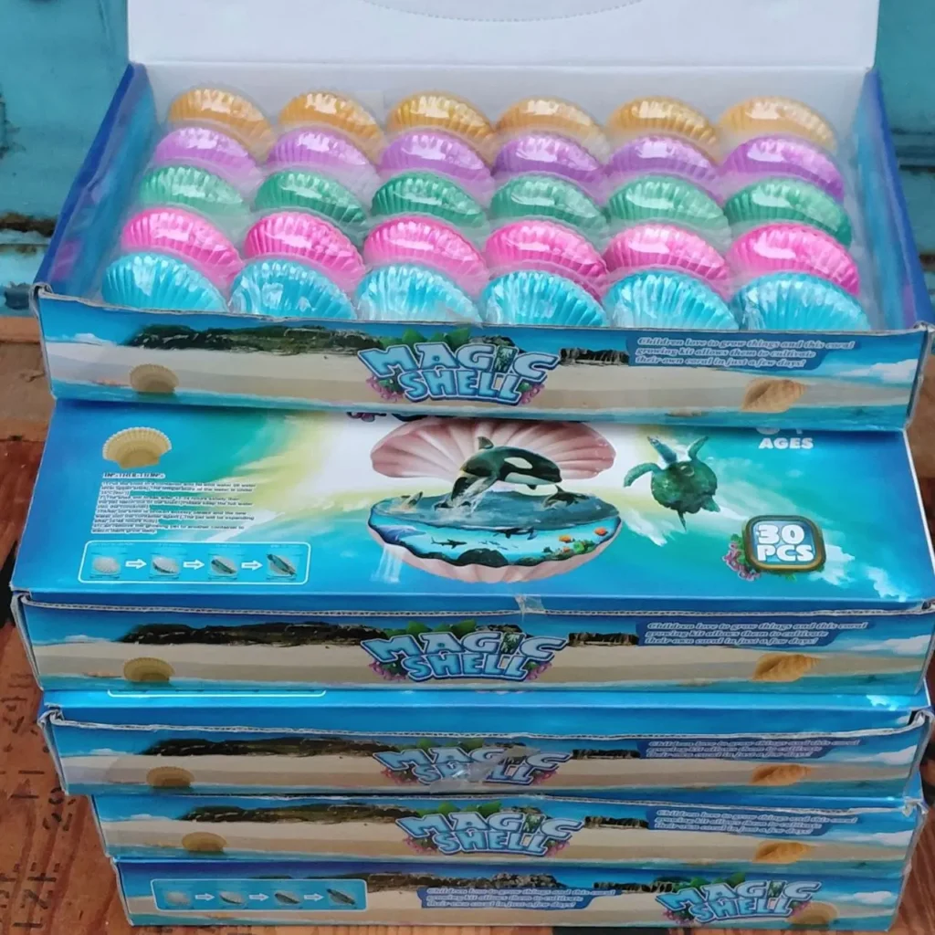 Cajas apiladas de kits de cultivo de coral Magic Shell con conchas de colores. by Remates Narvaja