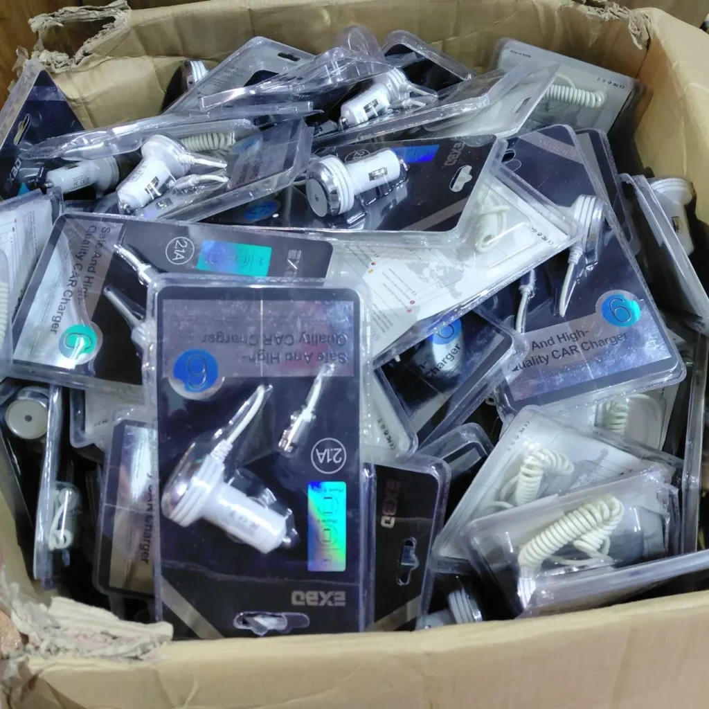Caja llena de cargadores USB de coche blancos empaquetados, muchos marcados como 2.1A. by Remates Narvaja