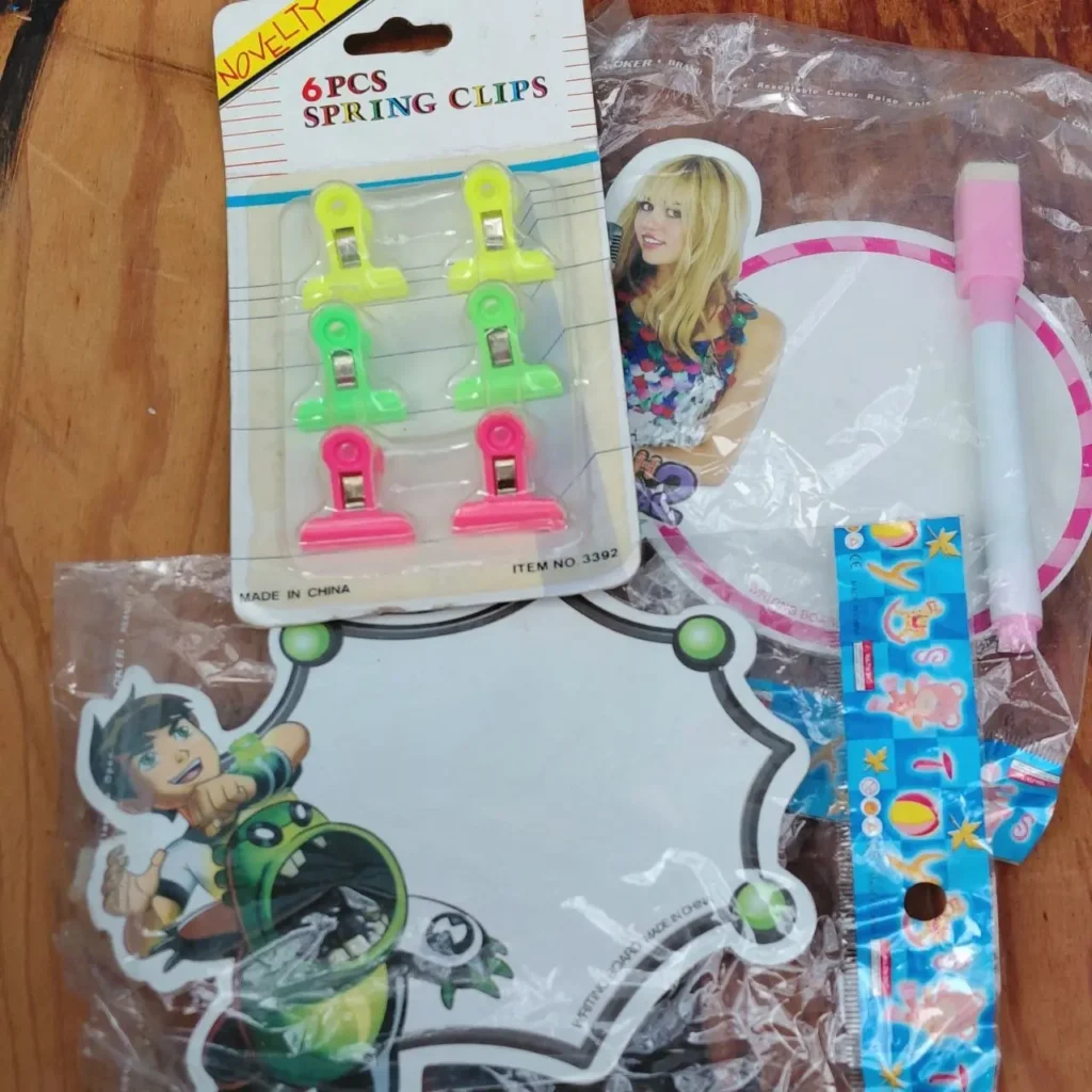 Pinzas de colores, pizarras borrables de Ben 10 y Hannah Montana, y útiles escolares empaquetados. by Remates Narvaja