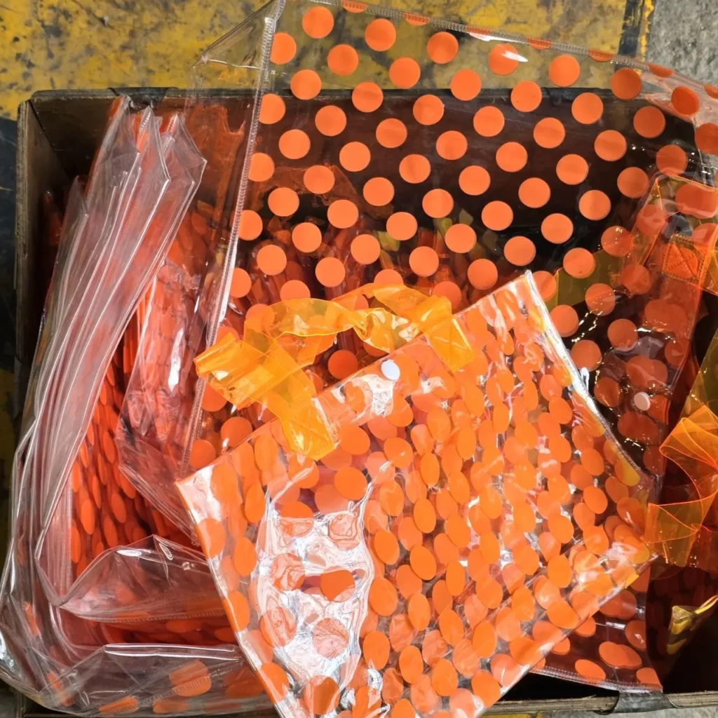 Bolsas transparentes de plástico con diseño de lunares naranjas en una caja. by Remates Narvaja