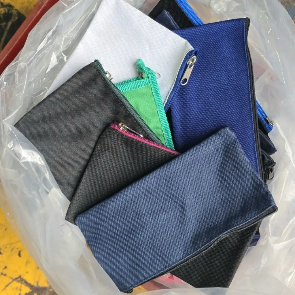 Bolsas de tela con cremallera de colores surtidos (azul, negro, blanco, verde) en una bolsa transparente. by Remates Narvaja
