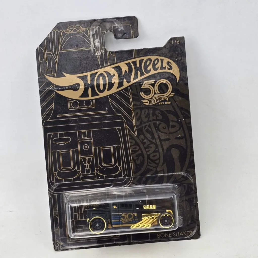 Hot Wheels Bone Shaker 50th Anniversary, coche de colección negro y dorado en su empaque original. by Remates Narvaja