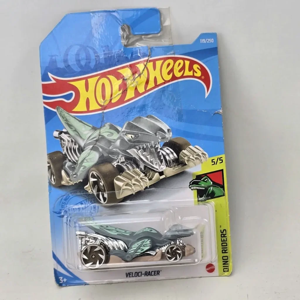 Coche de juguete Hot Wheels Veloci-Racer plateado y verde de la serie Dino Riders en su empaque. by Remates Narvaja