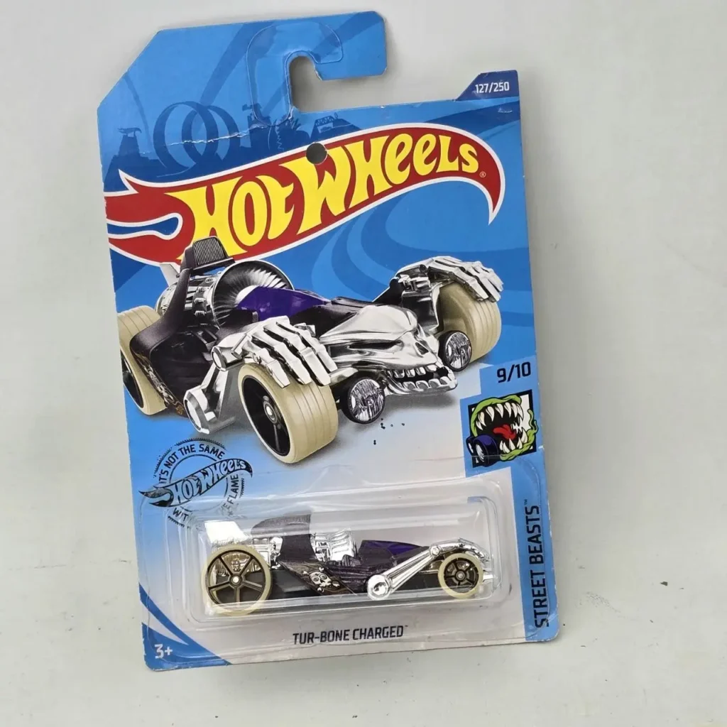 Hot Wheels TUR-BONE CHARGED Street Beasts, coche de juguete con diseño de calavera y manos esqueléticas en empaque azul. by Remates Narvaja