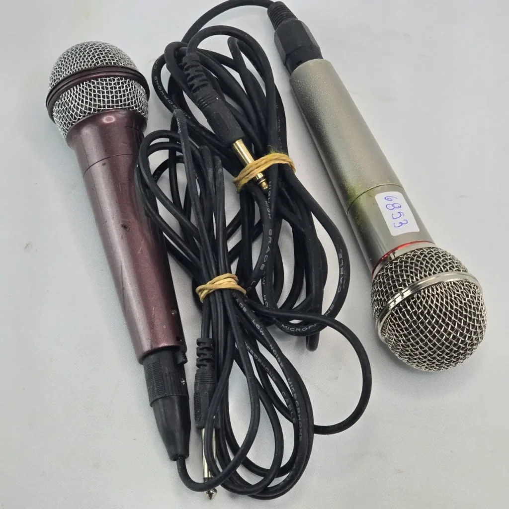 Dos micrófonos de mano con cable, uno morado y otro plateado, con sus cables enrollados. by Remates Narvaja