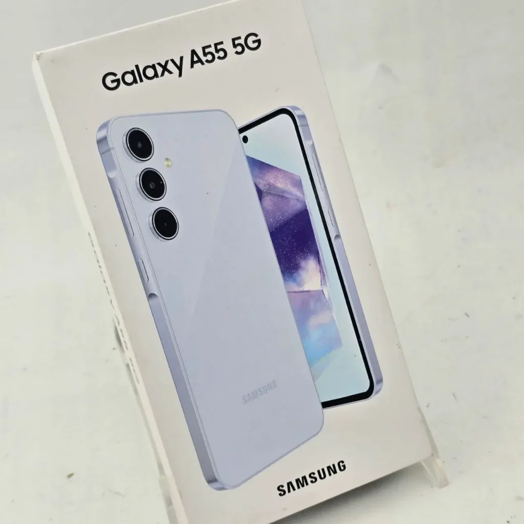 Caja del Samsung Galaxy A55 5G mostrando el smartphone en color lavanda con triple cámara trasera y pantalla encendida. by Remates Narvaja