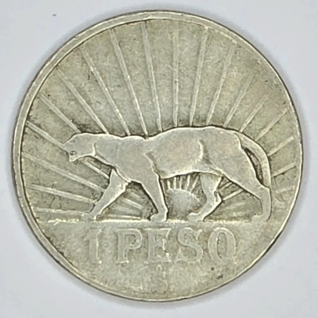 Moneda de 1 peso plateada con un puma caminando y rayos de sol. by Remates Narvaja
