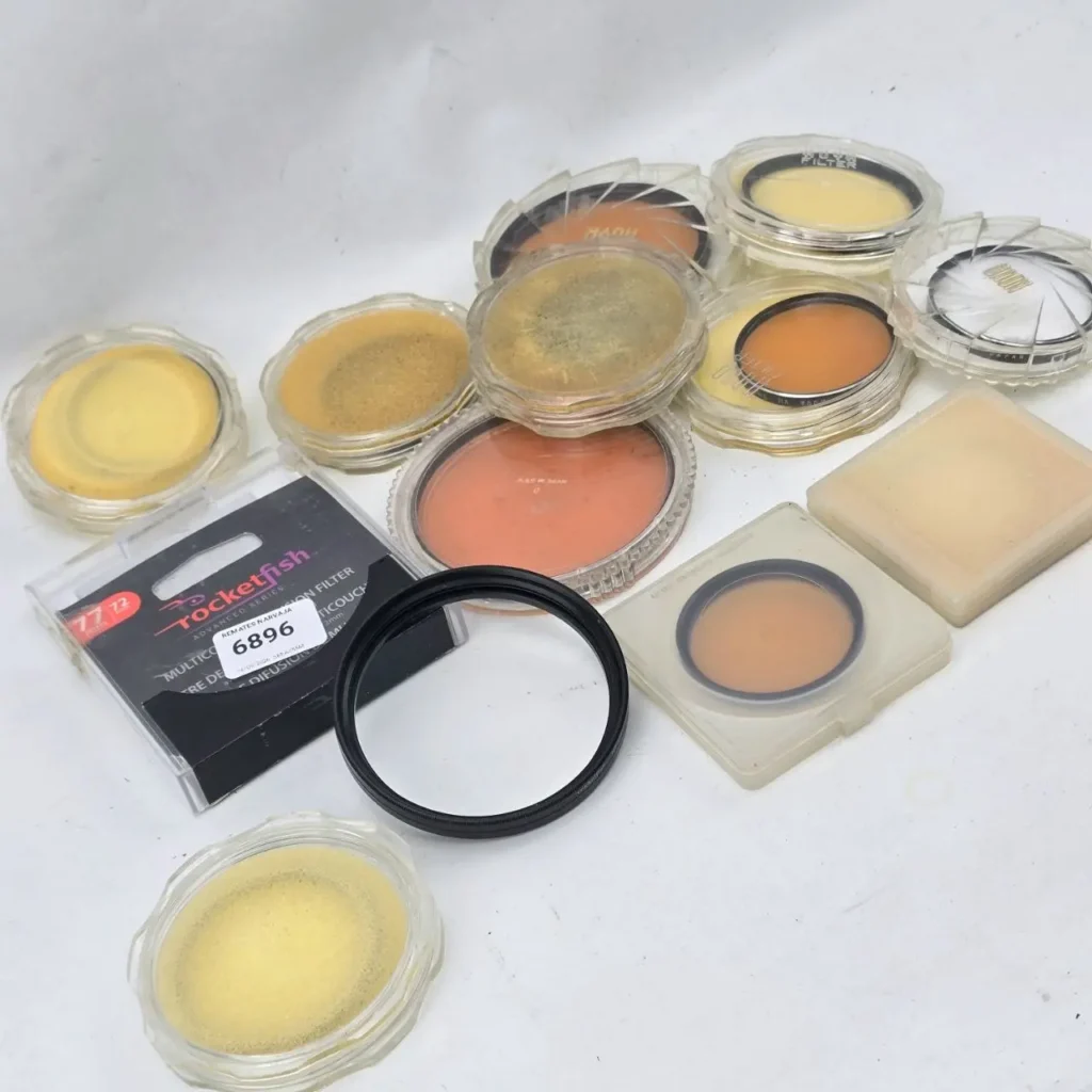 Colección de filtros de lente de cámara, incluyendo filtros de difusión Rocketfish y Hoya, en varios colores como amarillo, naranja y transparentes, dentro de estuches de by Remates Narvaja