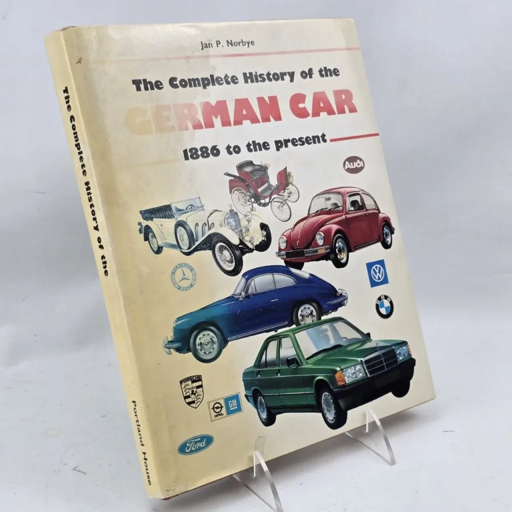 Portada del libro "The Complete History of the German Car" con ilustraciones de coches clásicos y modernos alemanes y logotipos de marcas. by Remates Narvaja