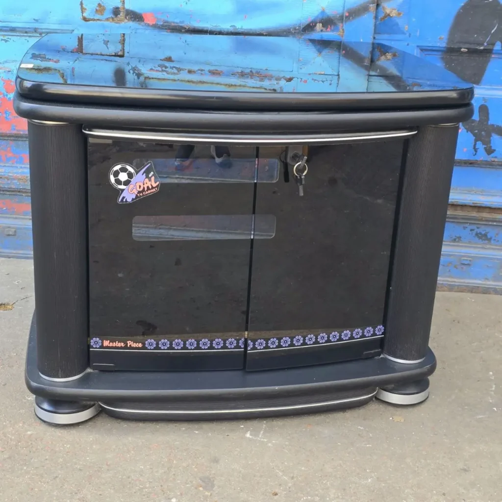 Mueble de TV negro curvo con puertas de cristal, logo "Goal TV Cabinet" y detalles plateados. by Remates Narvaja