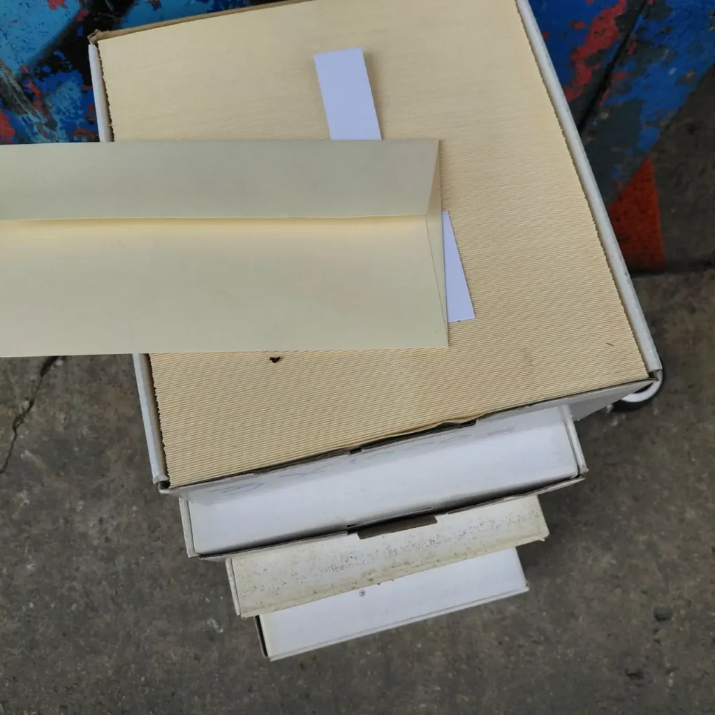 Pila de cajas de suministros con sobres beige y papel. by Remates Narvaja