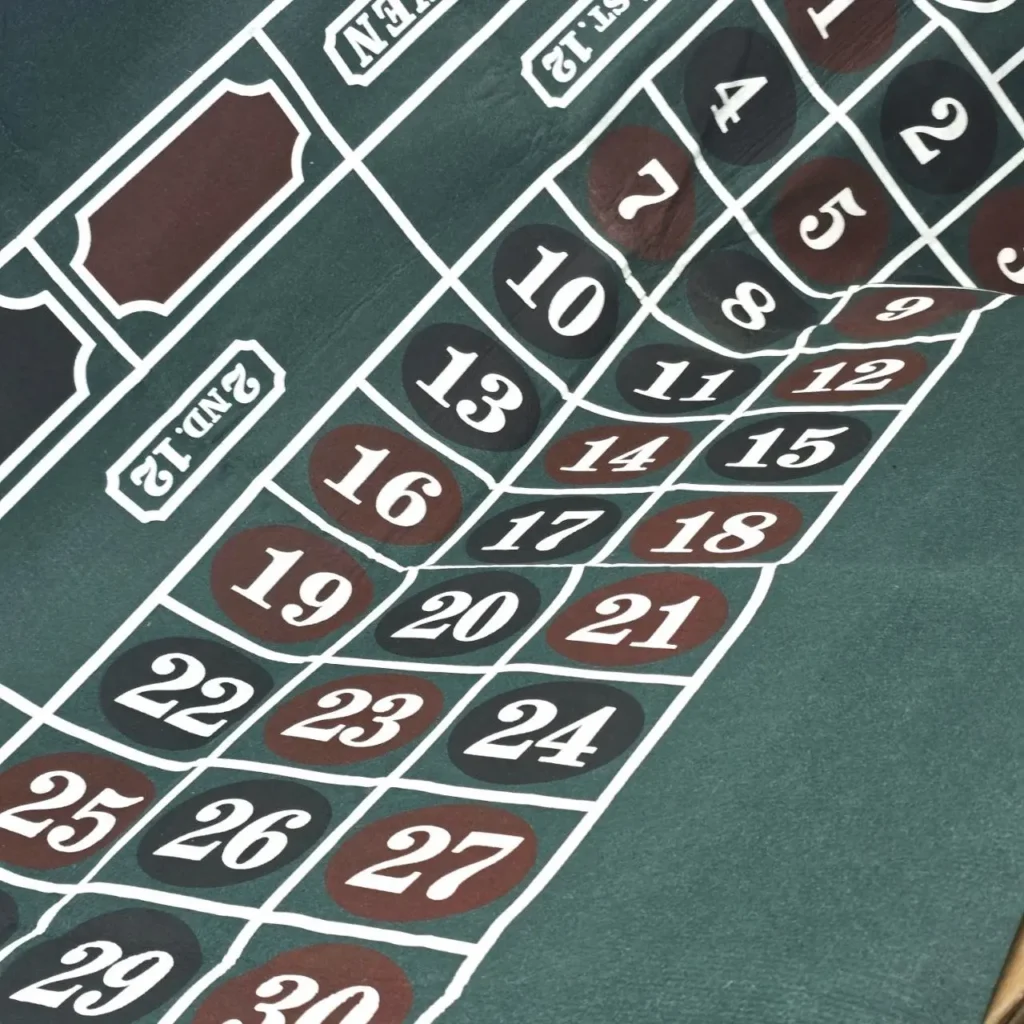 Primer plano de una mesa de apuestas de ruleta verde con números. by Remates Narvaja
