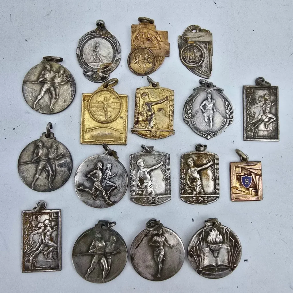 Colección de medallas antiguas con figuras de atletas, corredores y símbolos deportivos. by Remates Narvaja