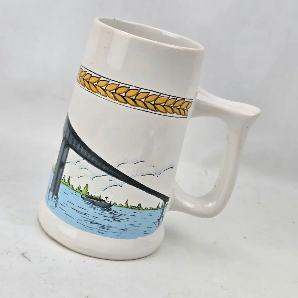 Jarra de cerveza blanca con dibujo de puente sobre el agua y borde de espigas. by Remates Narvaja