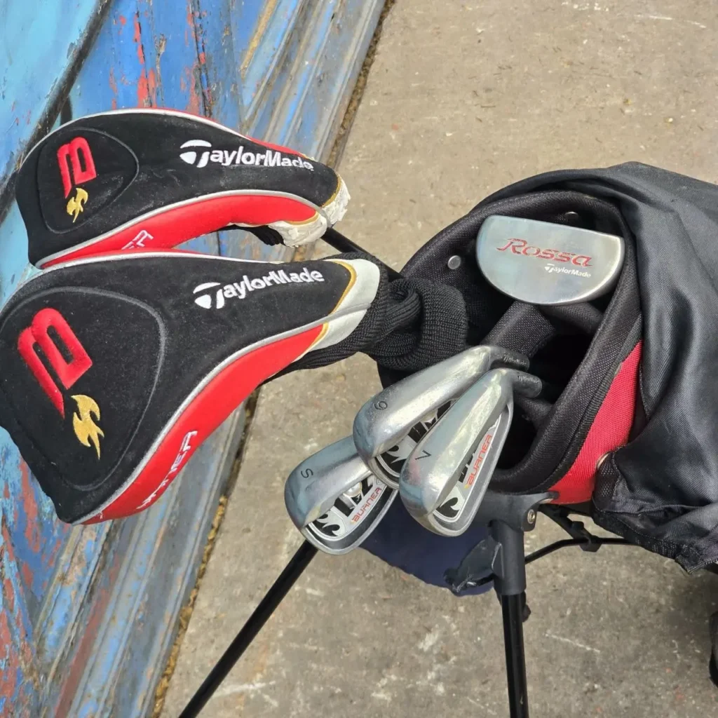 Palos de golf TaylorMade en una bolsa de pie negra y roja, incluyendo putter Rossa e hierros Burner. by Remates Narvaja