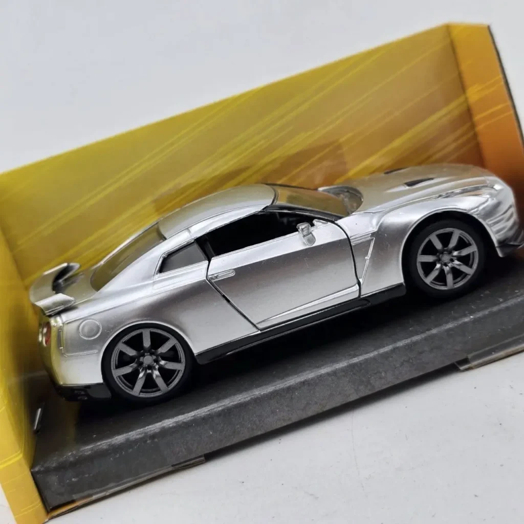 Réplica plateada de coche deportivo Nissan GT-R en su caja. by Remates Narvaja