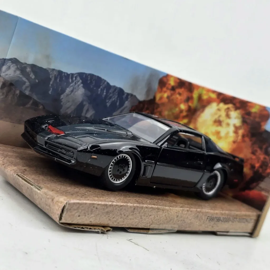 Modelo a escala del coche KITT de Knight Rider en negro, con fondo de explosión. by Remates Narvaja